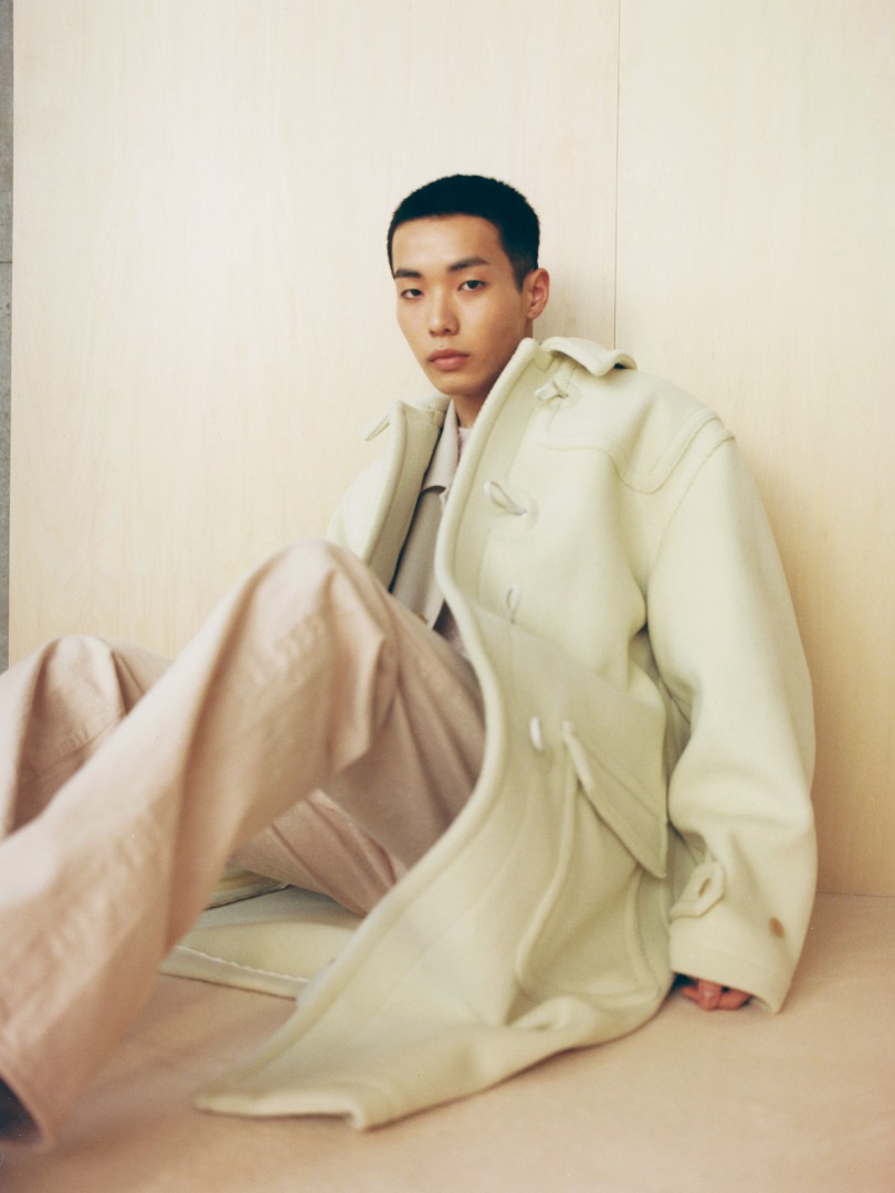 Yuta wears Wool Herringbone Pile Duffle Coat in Light Yellow, Botanical Dyed Selvedge Denim Pants in Natural Pink