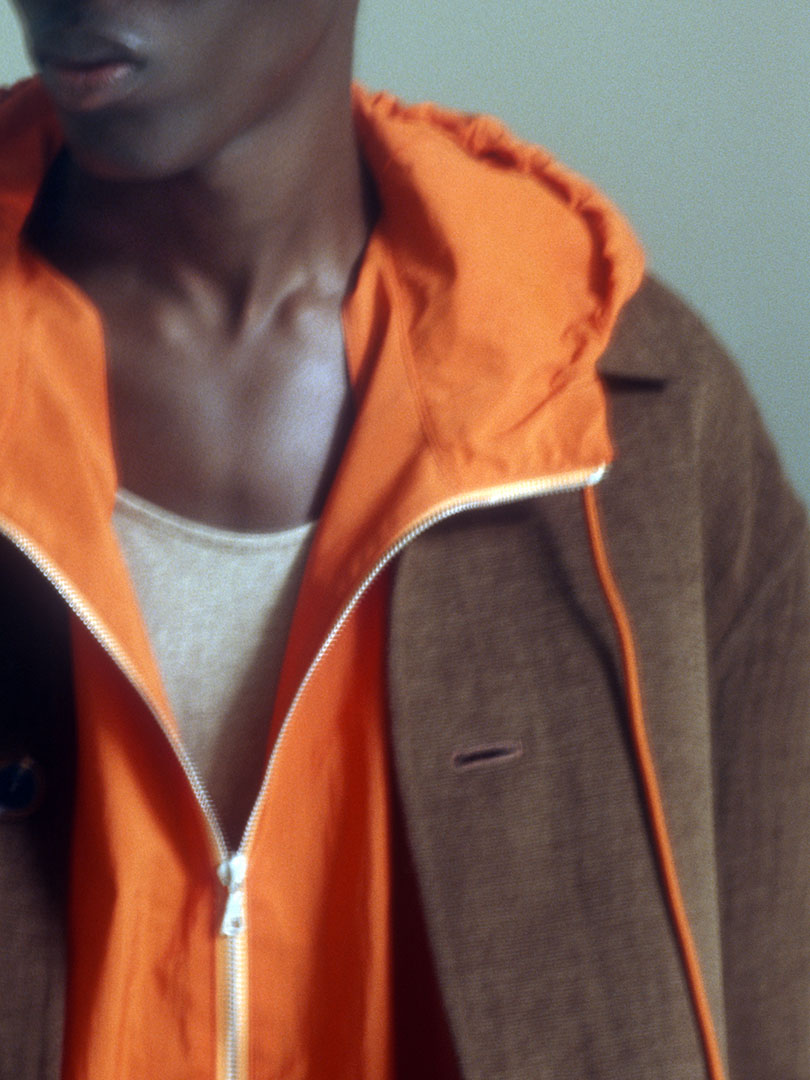 Raymond wears Cotton Mole Melton Hand Sewn Blouson in Brown, Washed Cotton Nylon Weather Hooded Zip P/O in Orange