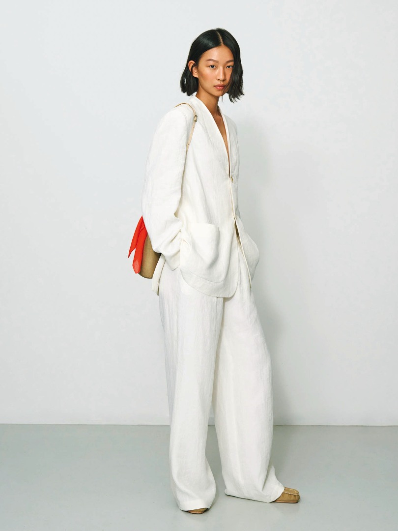 Hsiang wears Linen Gabardine No Collar Jacket in Ivory White, Linen Gabardine Slacks in Ivory White